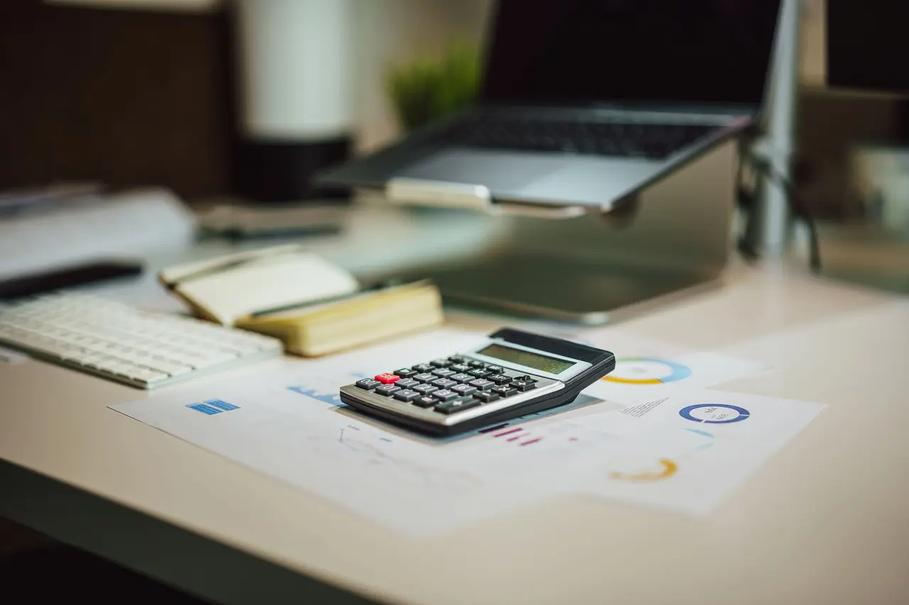 Calculator and documents arranged on a work desk