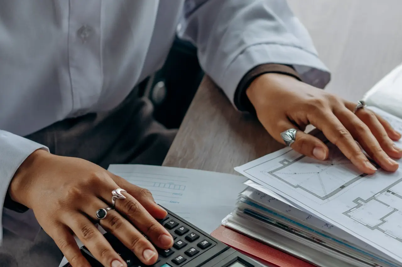 Contractor reviewing plans and estimate calculations at a desk