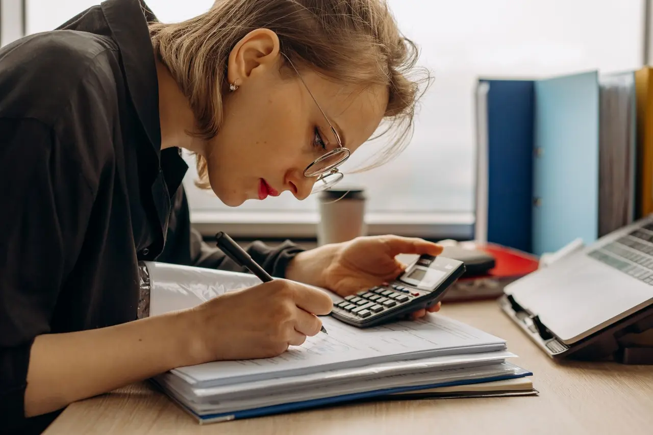 Business owner calculating costs from job records