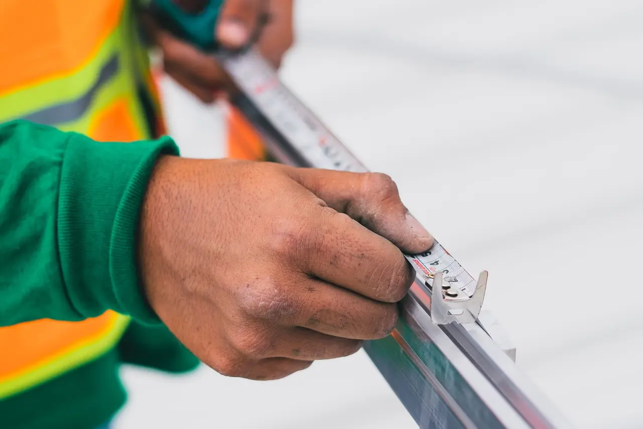 Construction worker measuring material carefully on a job site