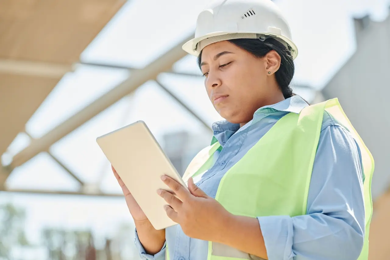 Construction professional using a tablet to manage field work